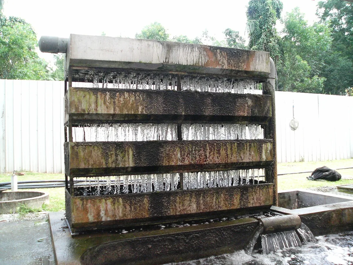 Een filterunit waarin water over meerdere lagen naar beneden stroomt en in een bak wordt opgevangen.